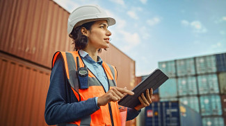 Person with tablet in container port